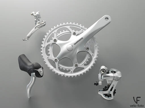 Shimano 2300.<br /><br />Младшая шоссейная группа. Имеет 2(3)х8 скоростей, «пистолеты» не имеют «дуал» переключения, а это значит, что переключение в одну сторону происходит с помощью самой ручки, а в другую, с помощью верхнего рычажка, визуализация скоростей присутствует. Используется каретка «под квадрат», всё оборудование делается из довольно дешёвых материалов, и как следствие это оборудование довольно тяжёлое и недолговечное.  Задний переключатель поддерживает работу со звездой до 26 зубьев, а систему на 2 звезды можно выбрать одну из двух, либо 52/39, либо 50/34.<br /><br />Обычно компоненты данной группы ставят на шоссейные велосипеды начального уровня. В принципе, нормальный выбор для тех, кто хочет купить первый шоссейник для «попробовать».<br /><br />Группа включает в себя: кассету, цепь, систему, передний и задний переключатели, шоссейные шифтеры или шифтеры для прямого руля.