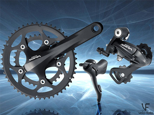 Shimano Sora.<br /><br />Группа, которая не далеко ушла от предыдущих двух, но имеет уже 2(3)х9 скоростную систему, и задние переключатели с короткой и длинной лапкой, что позволяет использовать переключатель, который лучше подходит для конкретного сочетания кассеты и системы.<br /><br />Для тех, кто не читал предыдущую часть, поясню, что для работы с определённым сочетанием кассеты и системы, требуется переключатели с разной ёмкостью. <br /><br />Ёмкость заднего переключателя — это сумма разниц размеров звезд в системе и в кассете, например:<br /><br />— система 50х34 — разница 16 «зубов»;<br /><br />— кассета 11х30 — разница 19 «зубов»;<br /><br />— ёмкость заднего переключателя должна быть не менее  35 «зубов».<br /><br />Обычно задние переключатели с короткой лапкой, имеют ёмкость 34 «зуба», когда как в переключателях c длинной лапкой ёмкость может достигать 40 «зубов». Кроме того, помимо ёмкости, каждый задний переключатель имеет предел на максимальную «звезду», обычно переключатели с короткой лапкой могут работать с максимальной звездой кассеты вплоть до 28-30 зубов, когда как переключатели с длинной лапкой могут работать с кассетами со «звездой» до 32 «зубов».<br /><br />Дуал системы доступны в вариантах 46/36 и 50/34, кассету можно ставить до 32 зубьев. В отличии от предыдущей группы, здесь (и во всех последующих группах) уже используется каретка Hollowtech II, которая обозначает интегрированную систему каретки и шатунов, что приводит к снижению веса, увеличению жёсткости и увеличения срока службы. Так же, как и в Claris используются переключатели «дуалконтрол» с визуализацией скоростей.<br /><br />Предназначена группа для любительского уровня катания, способна выдерживать регулярные выкатки на довольно приличные расстояния.<br /><br />Группа включает в себя: тормоза, кассету, цепь, систему, передний и задний переключатели, шоссейные шифтеры.